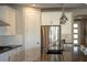Bright kitchen featuring an island with seating, white cabinets, stainless steel appliances, and modern pendant lighting at 32 Via Del Fiume, Henderson, NV 89011