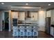 Bright kitchen featuring an island with seating, white cabinets, stainless steel appliances, and modern pendant lighting at 32 Via Del Fiume, Henderson, NV 89011