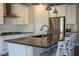 Bright kitchen featuring an island with seating, white cabinets, stainless steel appliances, and modern pendant lighting at 32 Via Del Fiume, Henderson, NV 89011