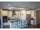 Bright kitchen featuring an island with seating, white cabinets, stainless steel appliances, and modern pendant lighting at 32 Via Del Fiume, Henderson, NV 89011