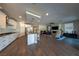 Open concept living area with modern kitchen, island with seating, and comfortable living room with fireplace and large screen television at 32 Via Del Fiume, Henderson, NV 89011
