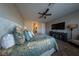Comfortable carpeted main bedroom with ceiling fan, dresser, television, and a beautifully decorated queen sized bed at 32 Via Del Fiume, Henderson, NV 89011
