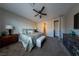 Comfortable carpeted main bedroom with ceiling fan, dresser, television, and a beautifully decorated queen sized bed at 32 Via Del Fiume, Henderson, NV 89011