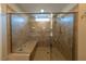 Modern bathroom shower with a glass door, bench seat, and tiled walls at 32 Via Del Fiume, Henderson, NV 89011