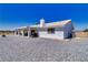 This rear exterior view features a covered patio and desert landscaping at 3581 Margarita Ave, Pahrump, NV 89048