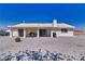 Rear exterior view featuring a covered patio, sliding glass doors, and desert landscaping at 3581 Margarita Ave, Pahrump, NV 89048