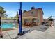 Rear exterior view of house with pool, covered patio with dining table, and car lift at 4990 Spring Oak St, Las Vegas, NV 89120