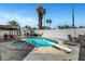 A pool and spa surrounded by palm trees, dining areas and a diving board for summer fun at 4990 Spring Oak St, Las Vegas, NV 89120