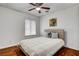 Bright bedroom with window, hardwood floors, ceiling fan, and a comfortable king-sized bed with white comforter at 4990 Spring Oak St, Las Vegas, NV 89120