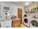 Bright laundry room featuring a sink, granite countertop, ample storage and modern washer and dryer at 4990 Spring Oak St, Las Vegas, NV 89120