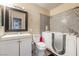 Bathroom featuring a walk-in tub with gray tile surround, modern vanity, toilet, and mirrored medicine cabinet at 5804 Apple Valley Ln, Las Vegas, NV 89108