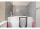 Bathroom with walk-in tub surrounded by attractive gray tile, safety grab bars, and a convenient handheld shower head at 5804 Apple Valley Ln, Las Vegas, NV 89108