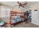 Well-lit bedroom with a ceiling fan, large window, bunk beds and an open closet with organized storage solutions at 5804 Apple Valley Ln, Las Vegas, NV 89108