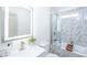 Bathroom featuring a marble tile shower-over-tub combination and a modern lighted mirror above a single sink vanity at 5822 E Carey Ave, Las Vegas, NV 89156