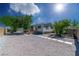 Exterior of a manufactured home with gravel landscaping and a shade tree at 5822 E Carey Ave, Las Vegas, NV 89156