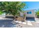 Inviting single-story home with gravel yard, wooden steps, and manicured potted plants near the door at 5822 E Carey Ave, Las Vegas, NV 89156