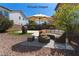 Virtually staged backyard with seating, umbrella, barbecue and decorative landscaping at 5912 Kit Cove Ct, Las Vegas, NV 89131