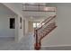 Bright, two-story foyer featuring tile flooring, a staircase with carpeted treads and dark wood railing at 5912 Kit Cove Ct, Las Vegas, NV 89131
