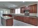 Open kitchen with cherry wood cabinets, granite countertops, stainless steel appliances, and tile flooring at 5912 Kit Cove Ct, Las Vegas, NV 89131