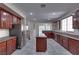 Open-concept kitchen featuring dark wood cabinetry, granite countertops, and tile flooring at 5912 Kit Cove Ct, Las Vegas, NV 89131