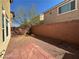 Small backyard featuring gravel, brick patio, brick wall, and blue skies at 6093 Crown Palms Ave, Las Vegas, NV 89139