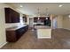 Modern kitchen boasting an island, dark cabinets, stainless steel appliances, and tile flooring at 6093 Crown Palms Ave, Las Vegas, NV 89139