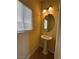 Chic half bathroom features a pedestal sink, round mirror, and modern lighting at 6093 Crown Palms Ave, Las Vegas, NV 89139