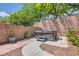Landscaped backyard featuring a relaxing hot tub, paved walkway, and mature trees for privacy and shade at 6329 Orange Hue St, North Las Vegas, NV 89031