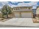 Charming two-story home featuring a tile roof and a three-car garage and manicured front yard at 6329 Orange Hue St, North Las Vegas, NV 89031
