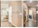 Hallway with tile floors leading to bathroom with glass shower and laundry area with modern washer and dryer at 6329 Orange Hue St, North Las Vegas, NV 89031