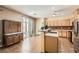 Well-lit kitchen boasts wooden cabinets, stainless appliances, and a bar-style counter for casual dining at 6329 Orange Hue St, North Las Vegas, NV 89031