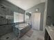 Modern bathroom featuring a soaking tub with marble surround, walk-in shower, and tiled floors at 640 House Blend Ln, Henderson, NV 89052