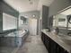 Modern bathroom with a soaking tub, walk-in shower, dual sinks, and marble tile at 640 House Blend Ln, Henderson, NV 89052
