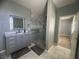 Modern bathroom with marble tile, glass shower, and gray vanity at 640 House Blend Ln, Henderson, NV 89052