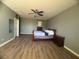 Bright bedroom with wood-look floors, ceiling fan, neutral walls, and ample space at 640 House Blend Ln, Henderson, NV 89052