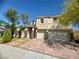 Two-story home showcasing a two-car garage, brick driveway, and lush landscaping at 640 House Blend Ln, Henderson, NV 89052
