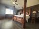 Spacious main bedroom with hardwood floors, four poster bed, and large bright windows at 640 House Blend Ln, Henderson, NV 89052