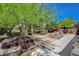 Backyard area with a covered hot tub, seating, and lush landscaping at 6409 Sea Swallow St, North Las Vegas, NV 89084