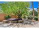 Backyard with covered hot tub, mature trees, and landscape lighting at 6409 Sea Swallow St, North Las Vegas, NV 89084