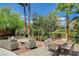 Backyard patio with outdoor seating and dining surrounded by lush landscaping at 6409 Sea Swallow St, North Las Vegas, NV 89084