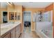 Well-lit bathroom featuring a double sink vanity, soaking tub, and walk-in closet at 6409 Sea Swallow St, North Las Vegas, NV 89084