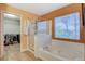 Well-lit bathroom with a walk-in closet, soaking tub, and shower enclosure at 6409 Sea Swallow St, North Las Vegas, NV 89084