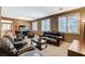 Well-lit living room with leather furniture, large windows, and an aquarium at 6409 Sea Swallow St, North Las Vegas, NV 89084