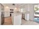 Bright, modern kitchen featuring white cabinetry, an island, stainless steel appliances, and sliding door to backyard at 6509 Alpine Winter Ct, Las Vegas, NV 89149