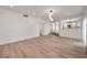 Open-concept living area showcasing wood-look flooring, a view to kitchen, and access to multiple rooms at 6509 Alpine Winter Ct, Las Vegas, NV 89149