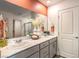 Bathroom featuring a double vanity with neutral countertops, stylish mirrors, and modern fixtures at 6533 Cinnamon Hazelnut St # Lot 94, North Las Vegas, NV 89084