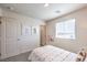 Bright bedroom with a neutral color scheme, featuring white doors, a window, and dog-themed art at 6533 Cinnamon Hazelnut St # Lot 94, North Las Vegas, NV 89084