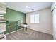Stylish bedroom features a green accent wall, a modern glass desk, and bright natural light from a window at 6533 Cinnamon Hazelnut St # Lot 94, North Las Vegas, NV 89084