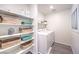 Functional laundry room with shelving units, decorative storage, and modern washer and dryer at 6533 Cinnamon Hazelnut St # Lot 94, North Las Vegas, NV 89084