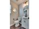 Stylish half bathroom with a modern vanity, round mirror and contemporary lighting at 680 Moonlight Stroll St, Henderson, NV 89002